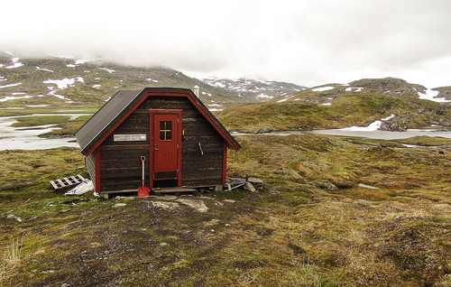 Hytta ved Krokvatnet. Bjørntoppen bak til høyre har fortsatt hatten på.