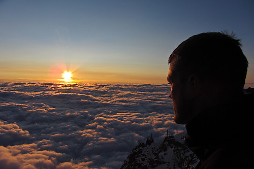 Øyvind nyter kveldssola over skyhavet fra Refuge Cosmiques.