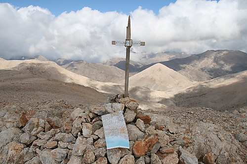 Toppvarden og utsikt nordover. Den koniske toppen i sola rett til høyre for korset er på 2225 moh og korset skjuler fjellhytta Katsiveli. 