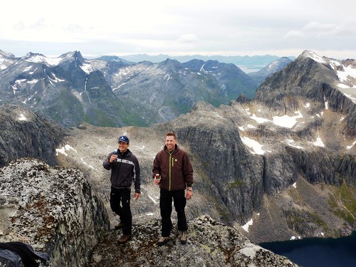 Two happy guys on a mountain top with beers.