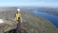 Chris er fornøyd på toppen. Bygdin i retning østover og Vinstervatnet langt der bak.